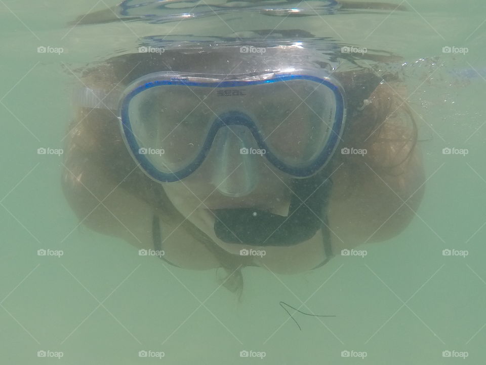A young woman snorkeling through the warm waters of the Florida coast.