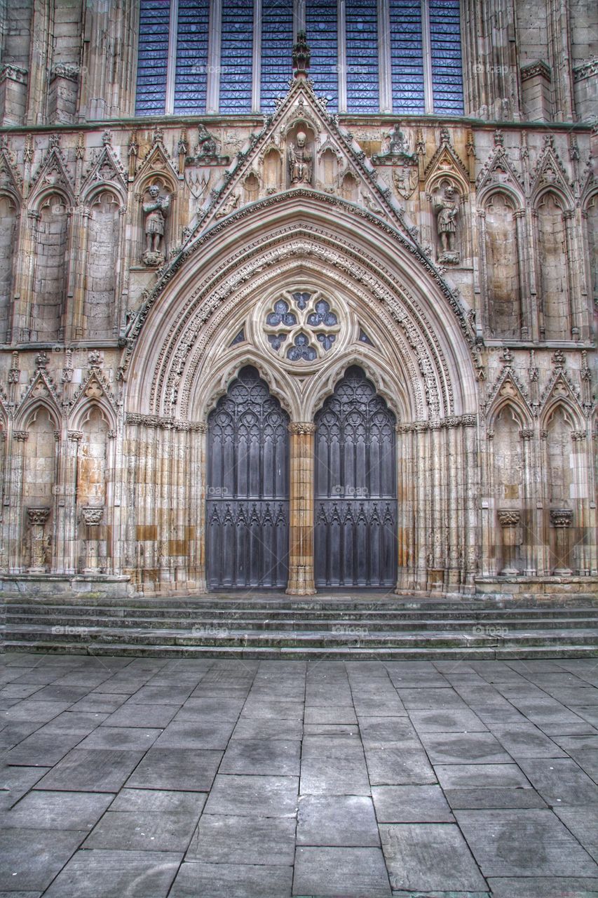 The main entrance to York Minster. Elaborate church door with ornate stone carvings.