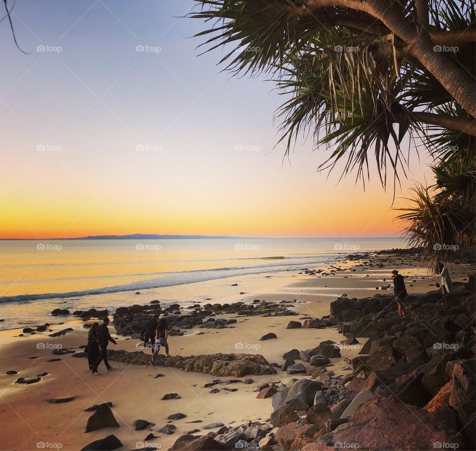 At the tropical rocky beach at sunset in Australia 