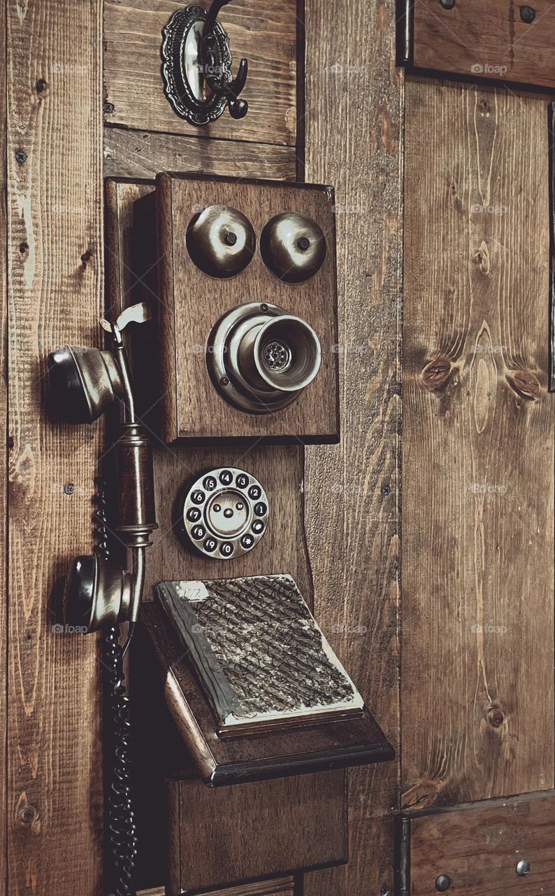 An old phone on a wooden wall