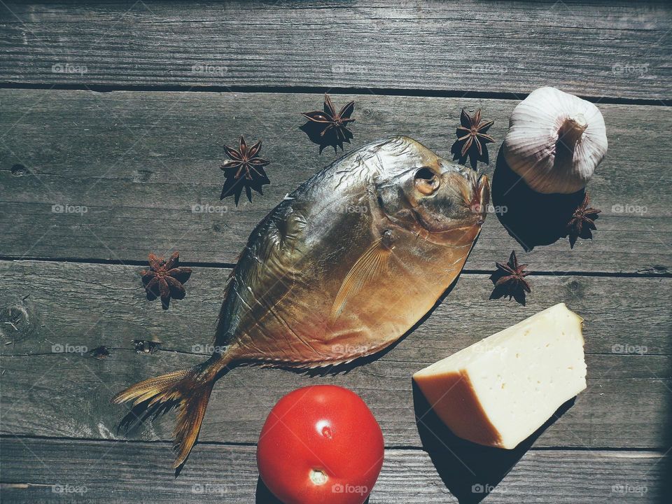 dried fish, tomato, cheese and garlic on a table