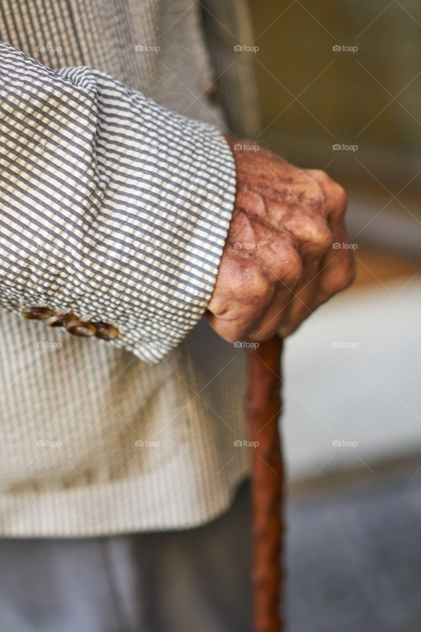 Aging hand with walking stick