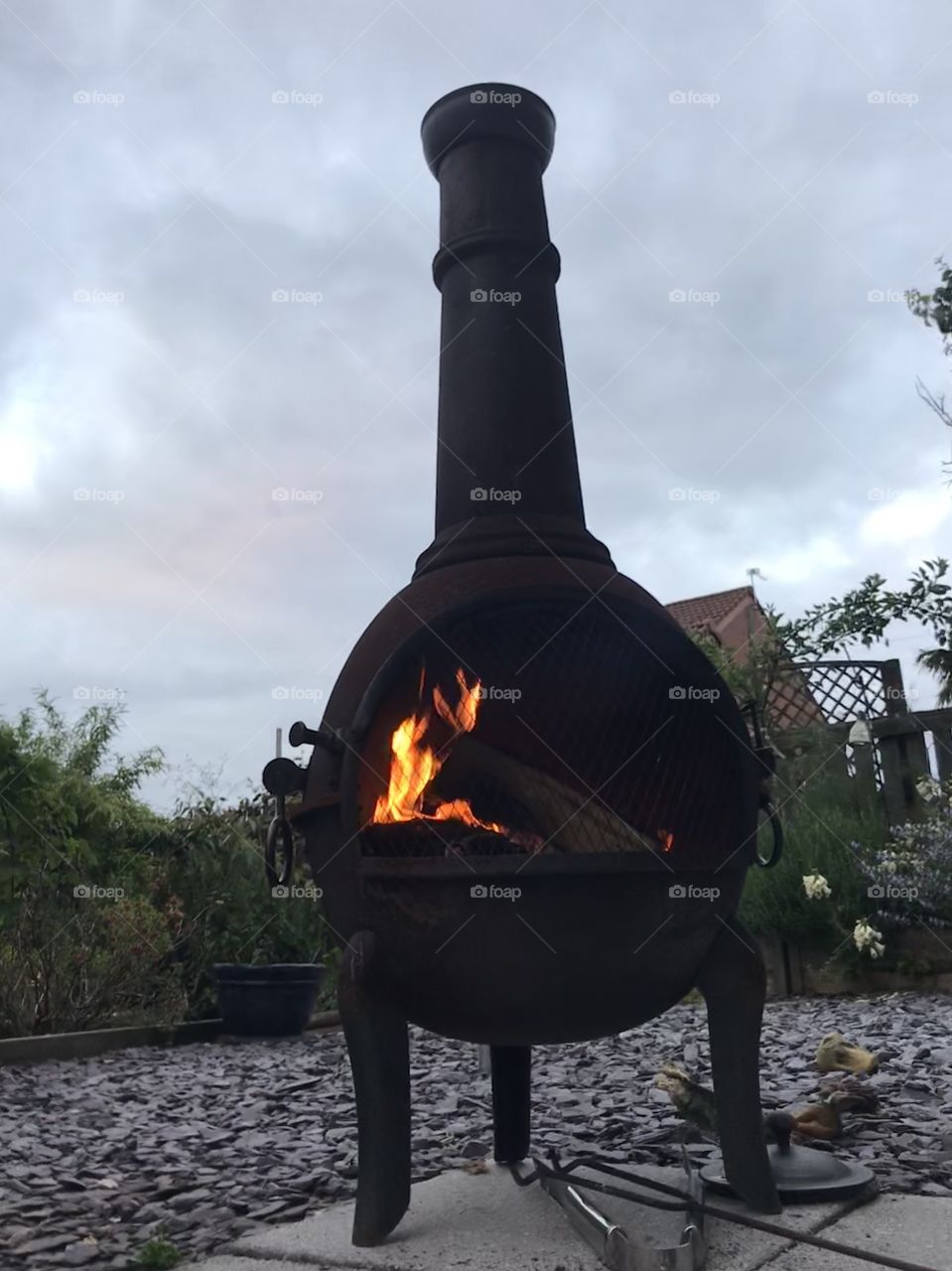 Lit chiminea against a cloudy backdrop. 