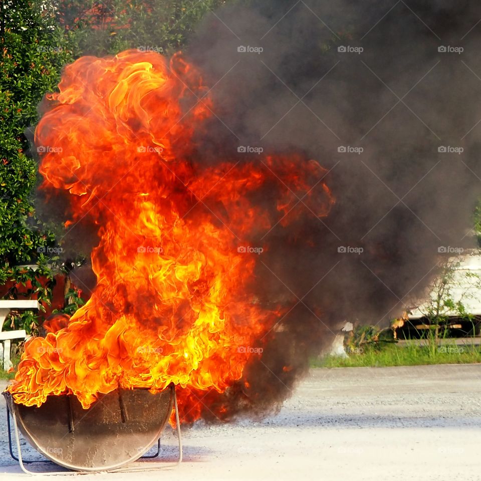 Controlled explosion which created a red flame inside a cut-in-half metal container.