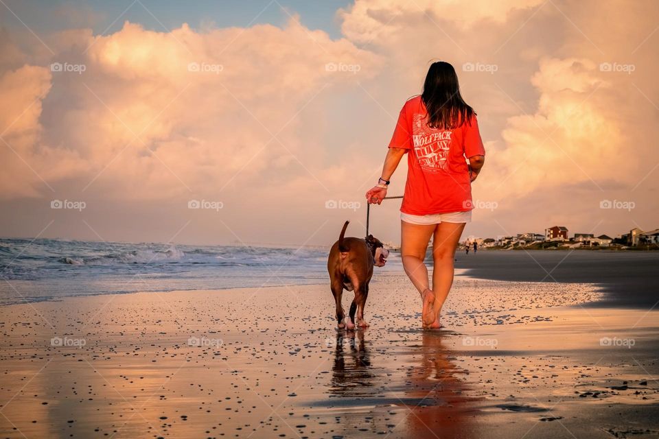 Best friends enjoy an early morning walk on the beach. Emerald Isle, North Carolina. 