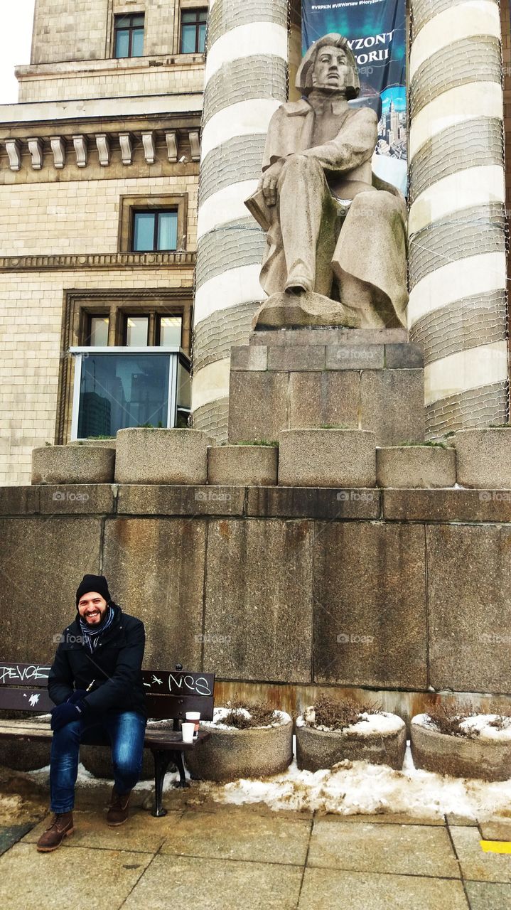 Man sitting on bench near statue