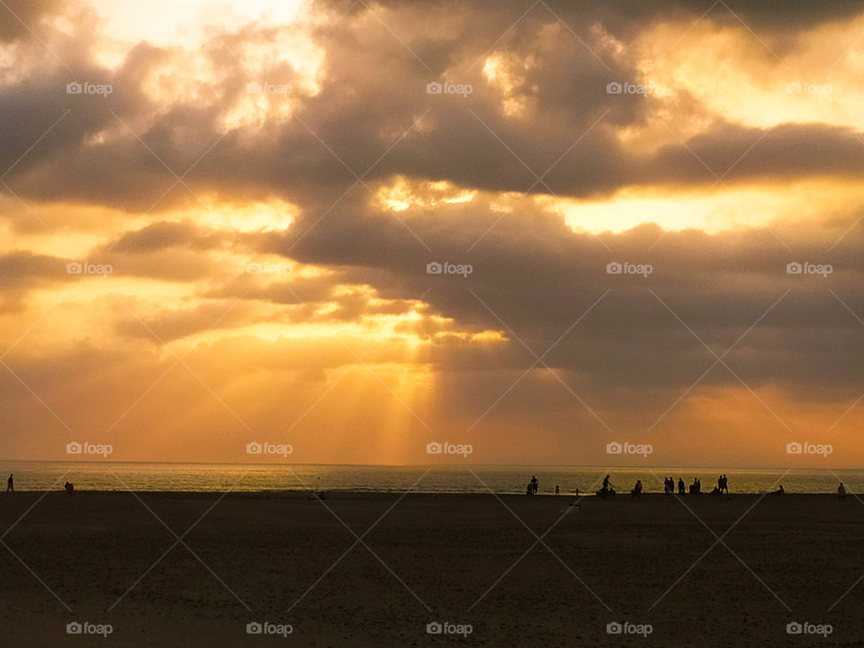 atardecer en la playa de conil , puesta de sol con un dia nublado