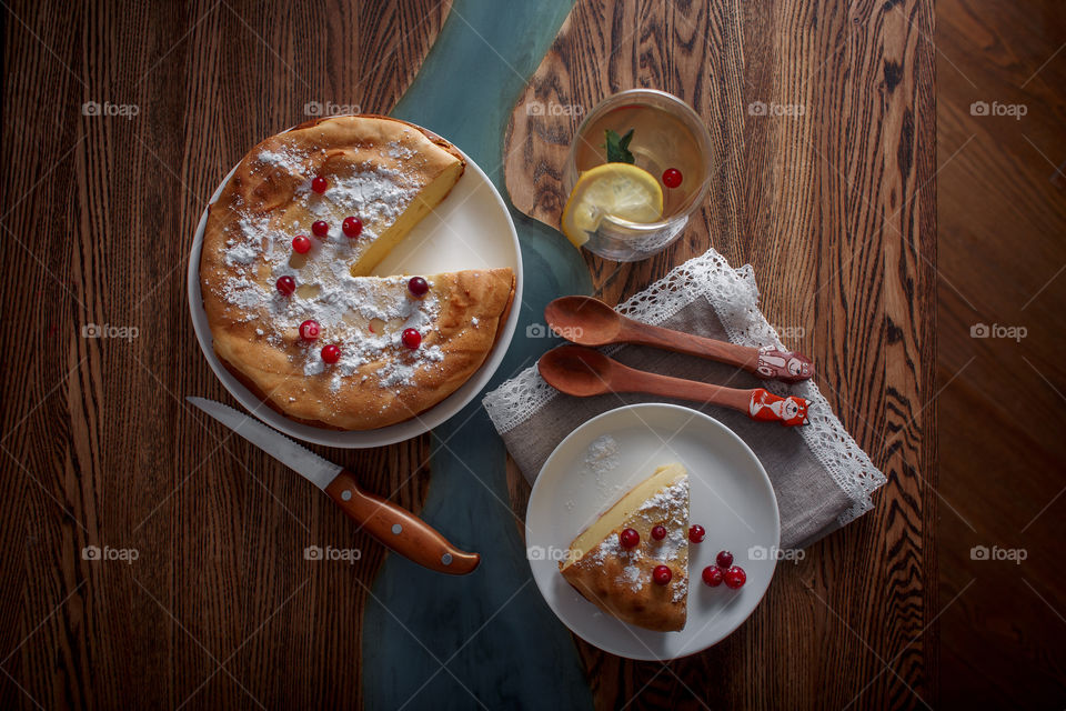 Cheesecake with cranberries and sugar on wooden background