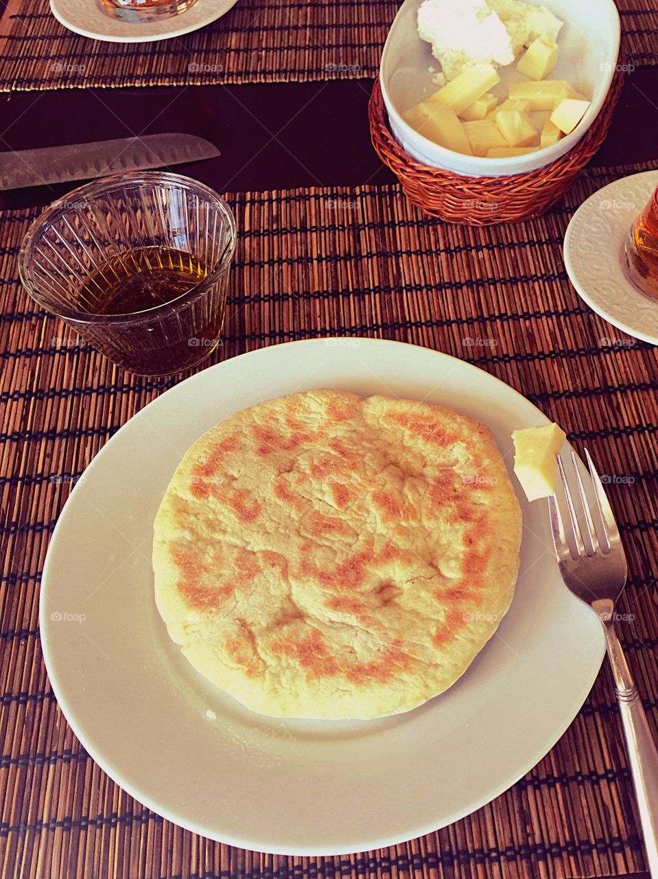 Single layered flat circle bread with a piece of cheese and olive oil