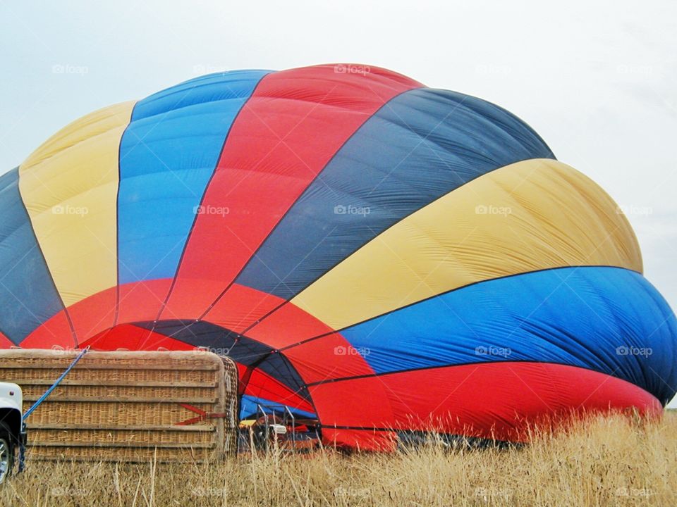 Inflating a hot air balloon . A hot air balloon with colorful stripes partially inflated 
