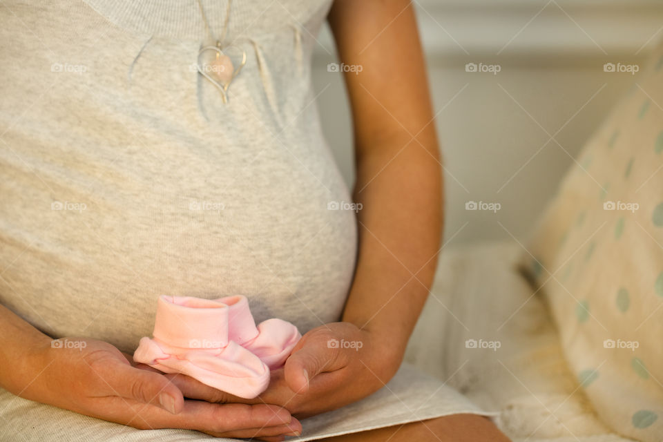 Midsection view of pregnant women with baby booties