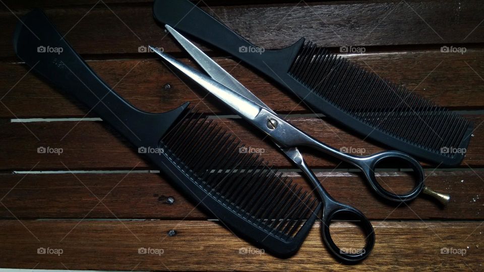 scissor and comb on wooden background