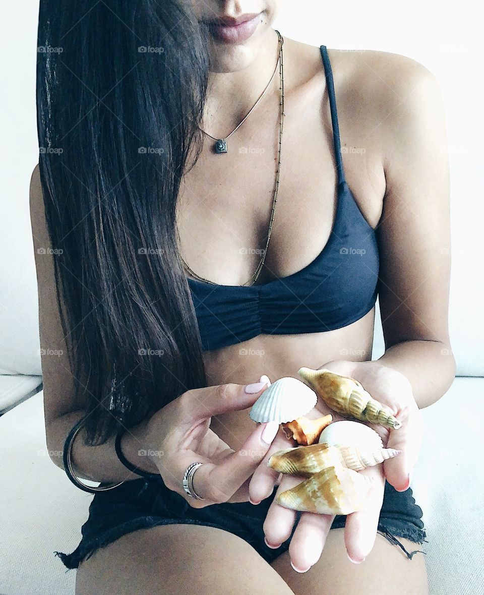 Young woman holding seashells 