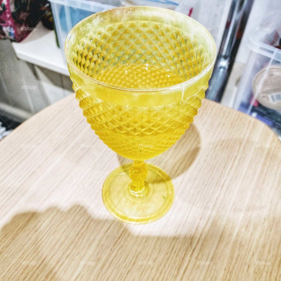 A kooky still-life wine glass. For some reason it reminds me of sherbet lemons and the intensity of the yellow is captivating among the dancing shadows.
