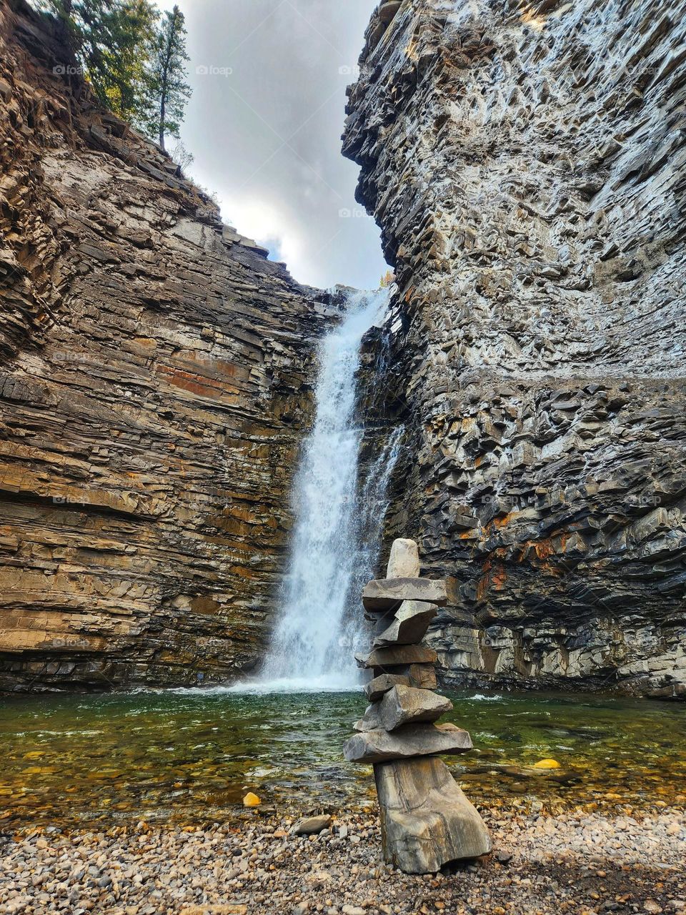 Rock stacking at the base of a mighty waterfall