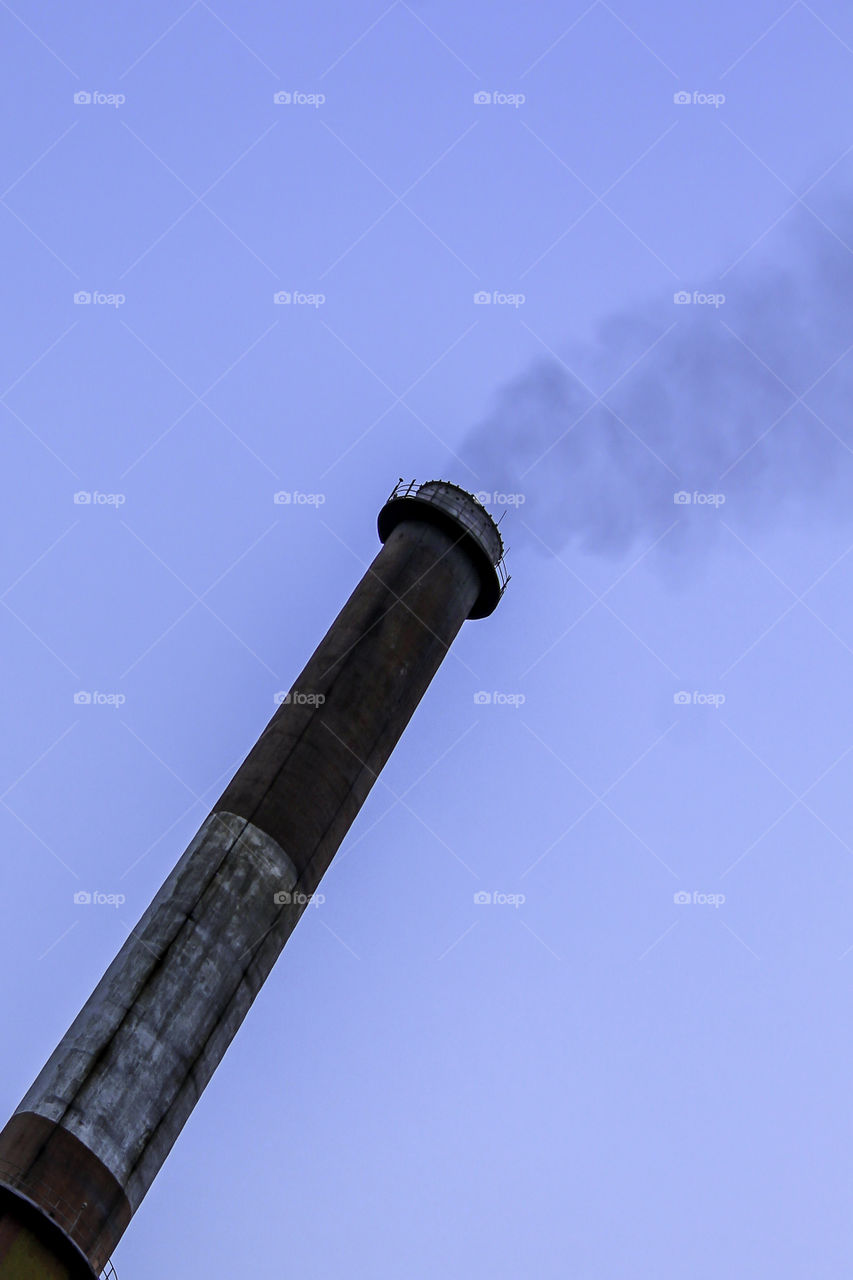 Exterior of maintenance and ventilation on top of a smoke tunnel, chimney for ventilation. Isolated old aged weathered tall industrial factory chimney grungy smokestack grunge vintage closeup blue sky