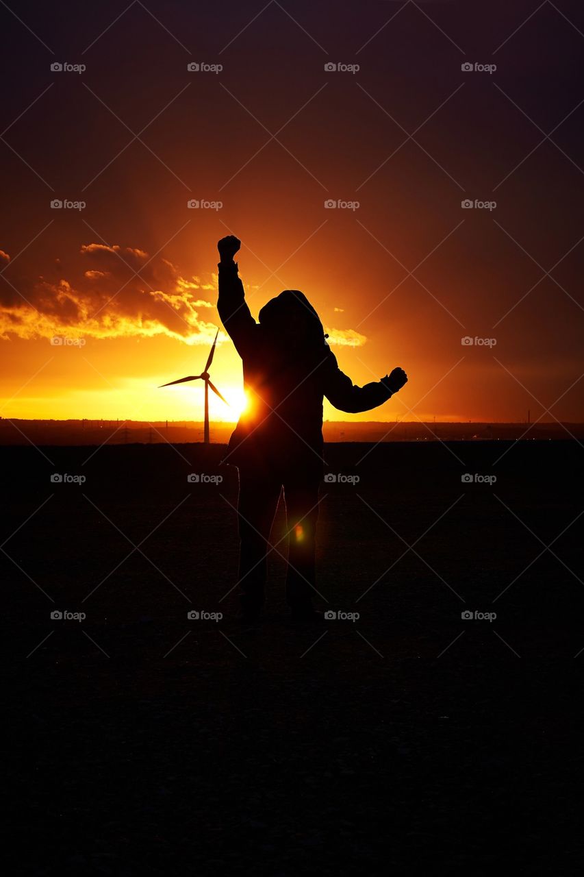 Man showing happines at sunset with mind mills in background