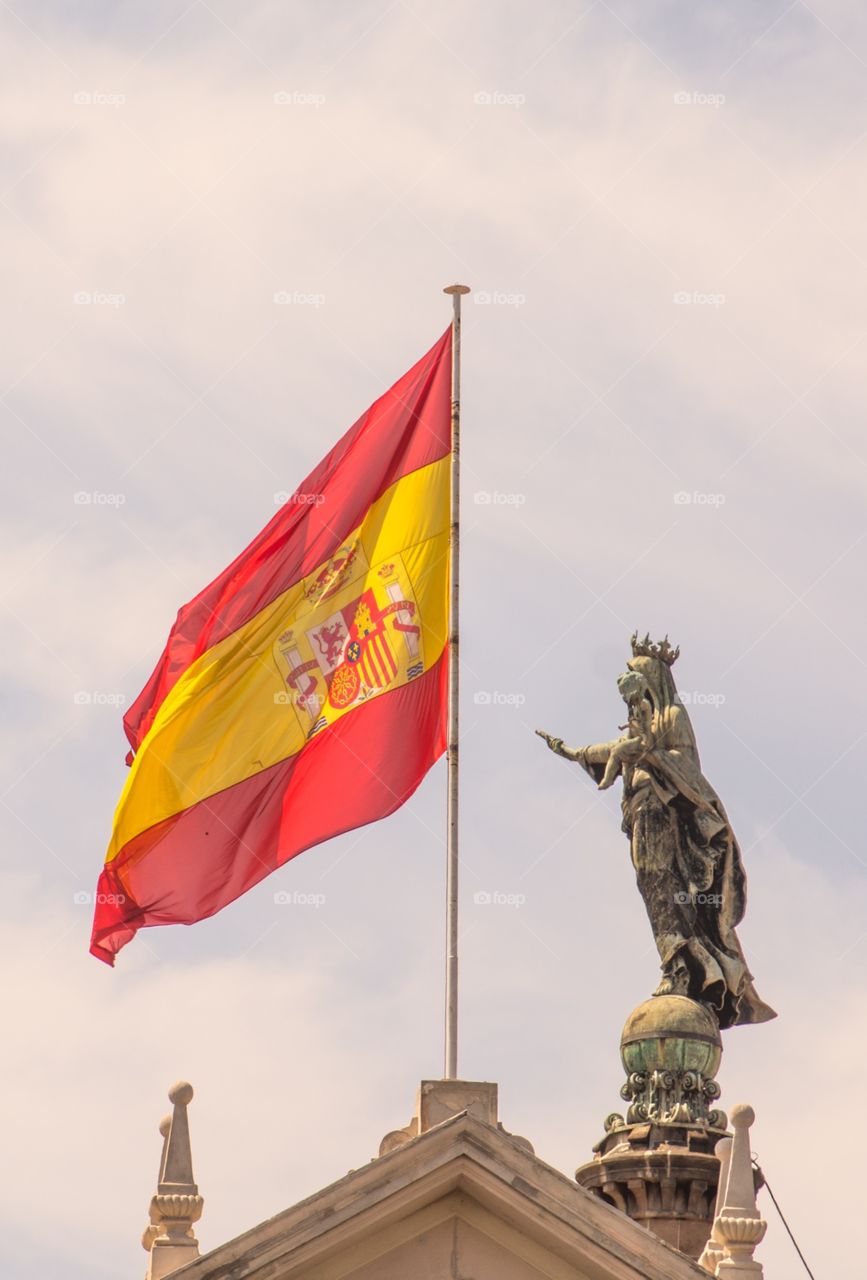 The Spanish flag next to a statue