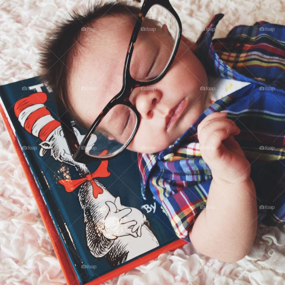 Baby in glasses with books