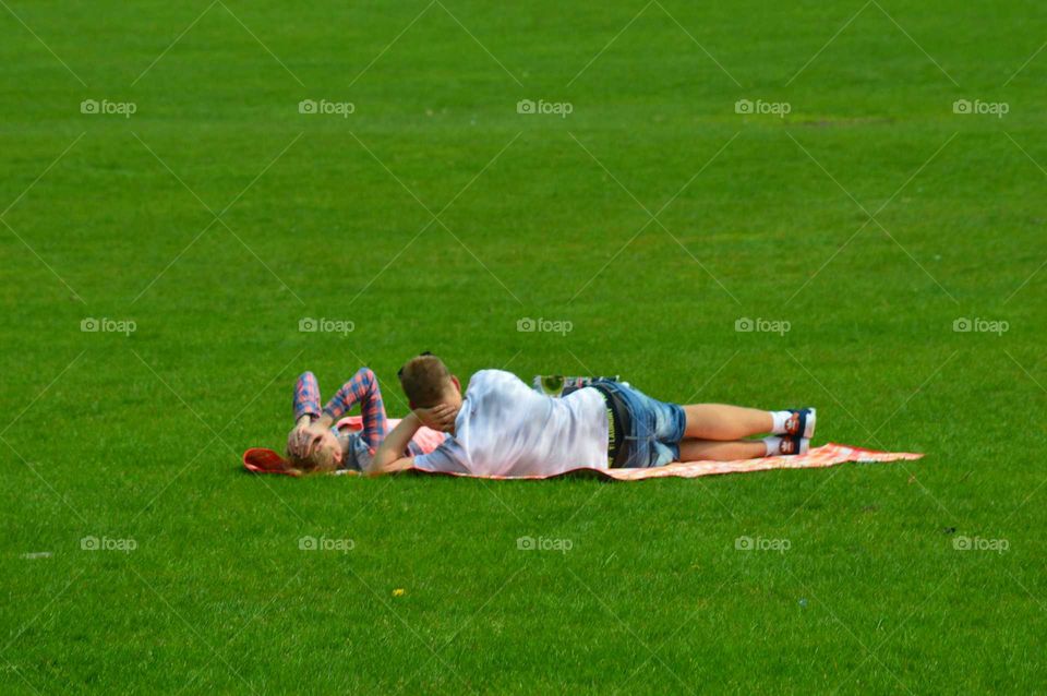 young couple lies on grass