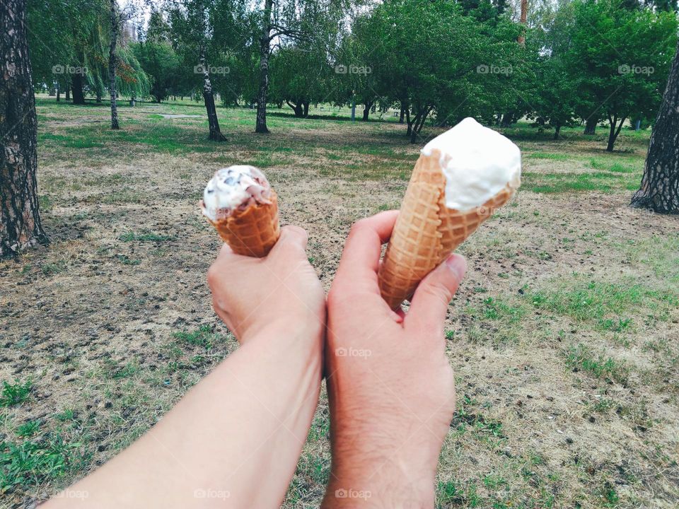 Men's and women's hands hold ice cream