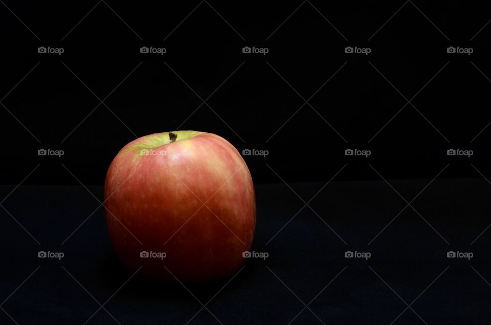 Studio photo of a red apple on black background