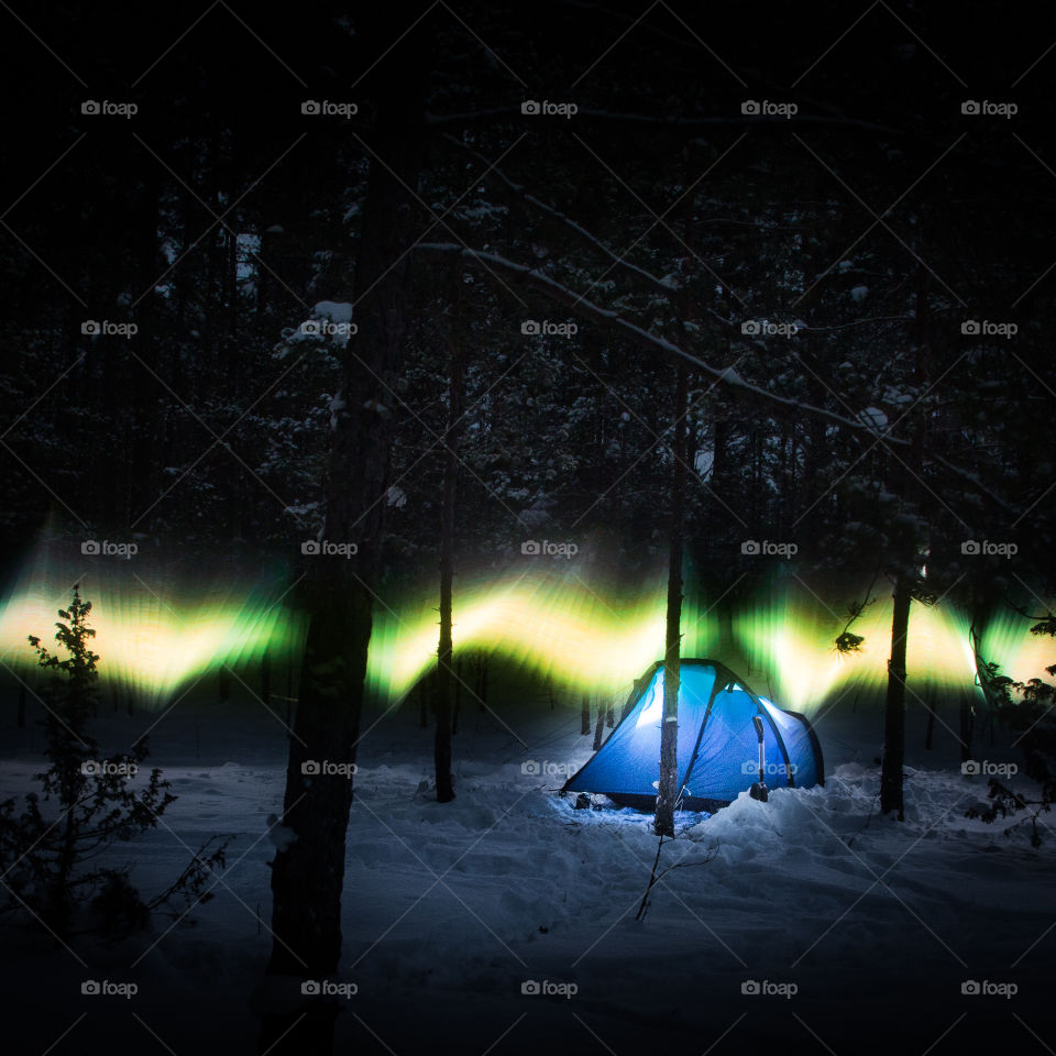 Aurora look alike in the winter forest with tent.