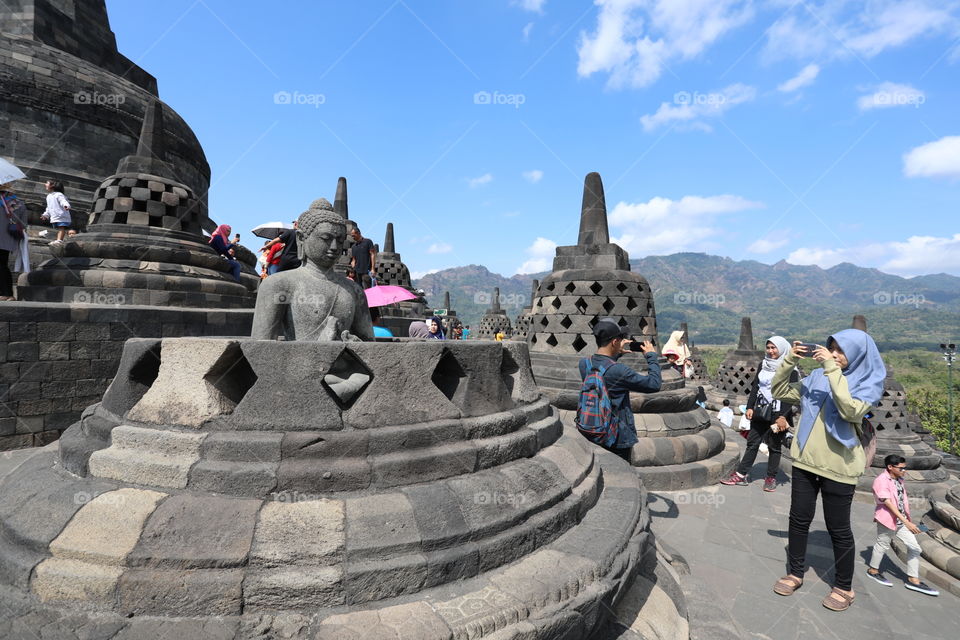 Tourists take photos of the Buddhist temple of Borobudur near Yogyakarta, Indonesia