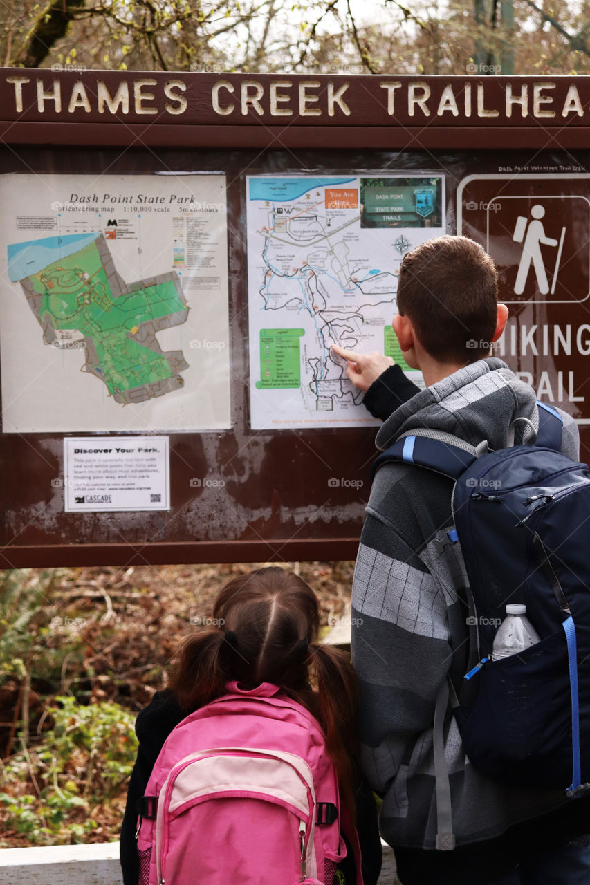 Big brother checks out the map before taking little sister on a hike