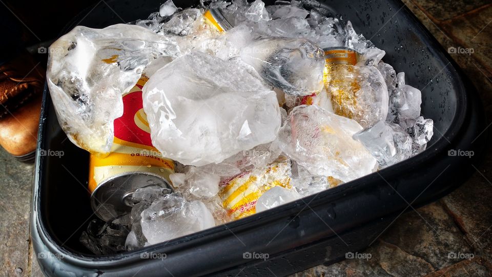Galde com latinhas de cerveja e gelo quebrado.
