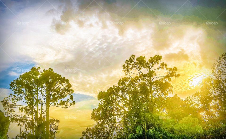 Golden sunset glowing through dark clouds.