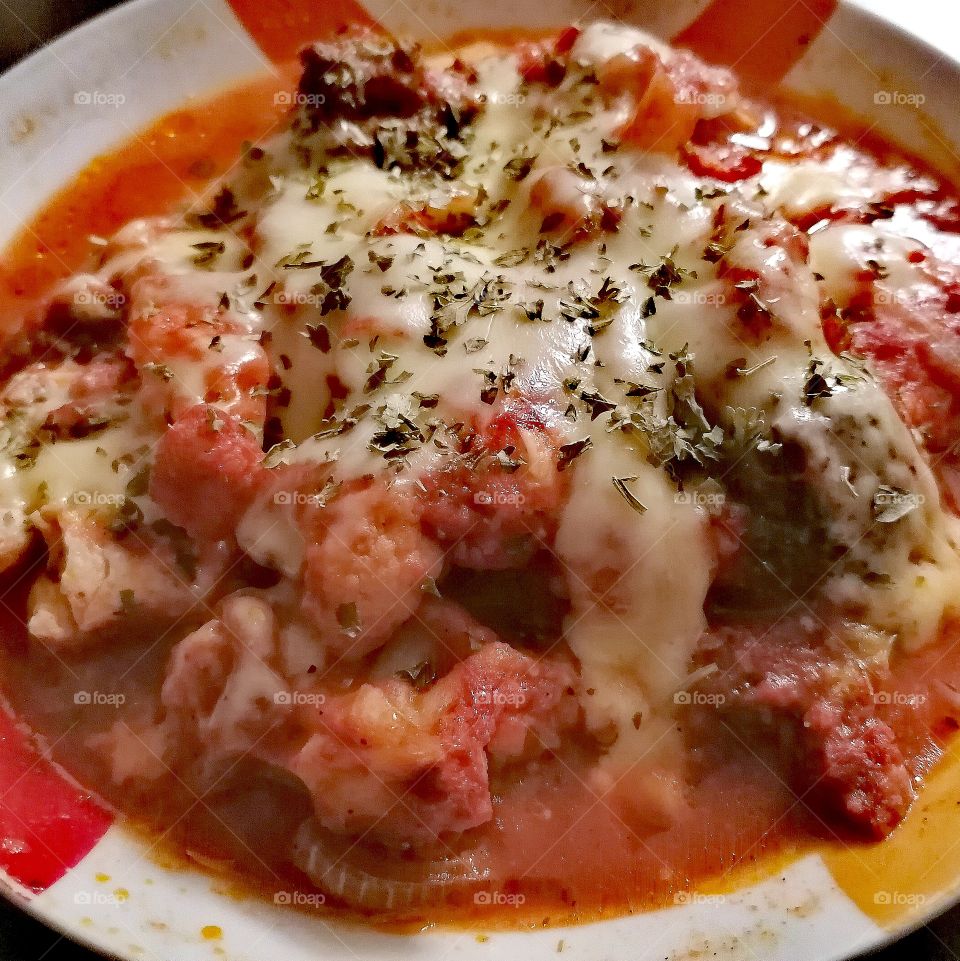 Baked chicken in tomato sauce with onions and cheese