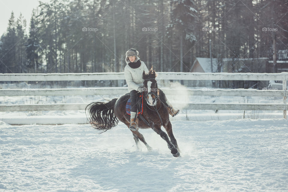 Teenage girl horseback jumping at cold winter day