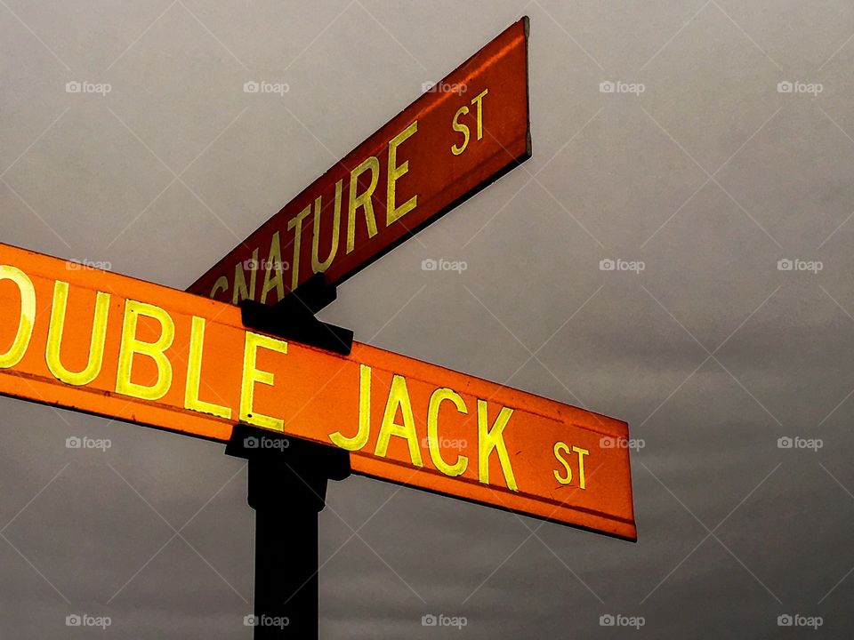 Double Jack and Signature red street signs against sky