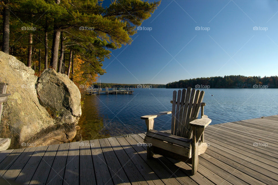 Adirondack chair on a dock by the lake