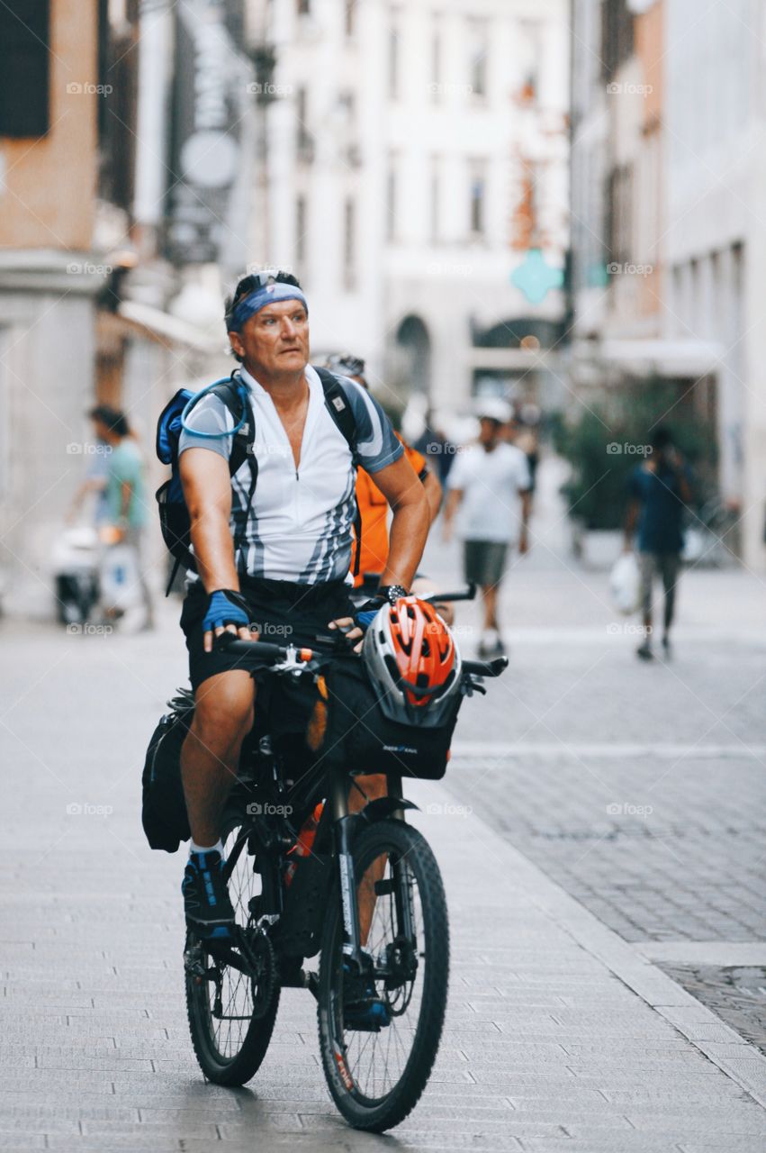 Old man cycling in the city 