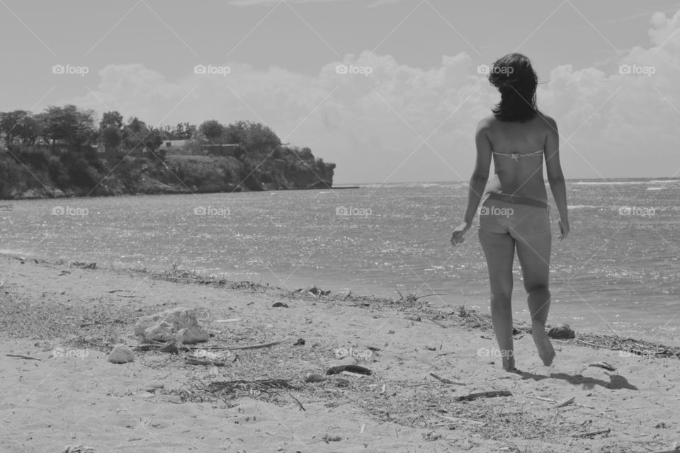 Rear view of woman in bikini walking at beach