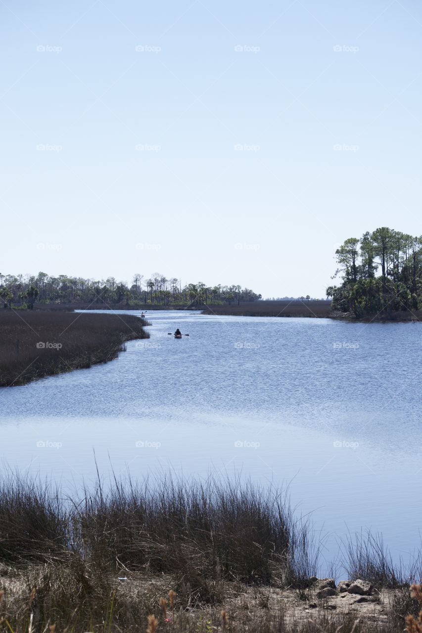 Distant view of person paddling in river