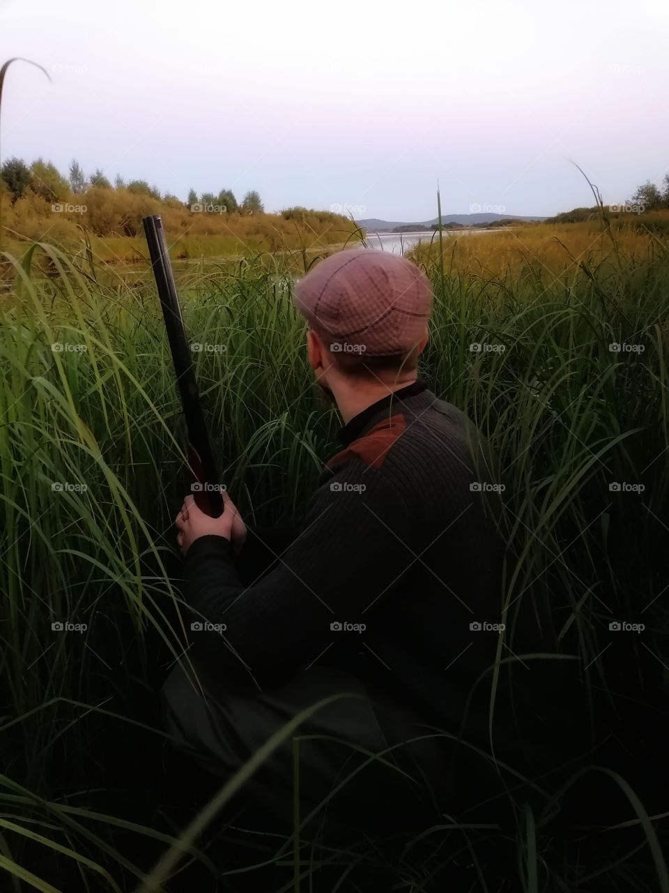 A man on a duck hunt in Lapland, Finland. Just have to wait for the birds evening flight hidden.