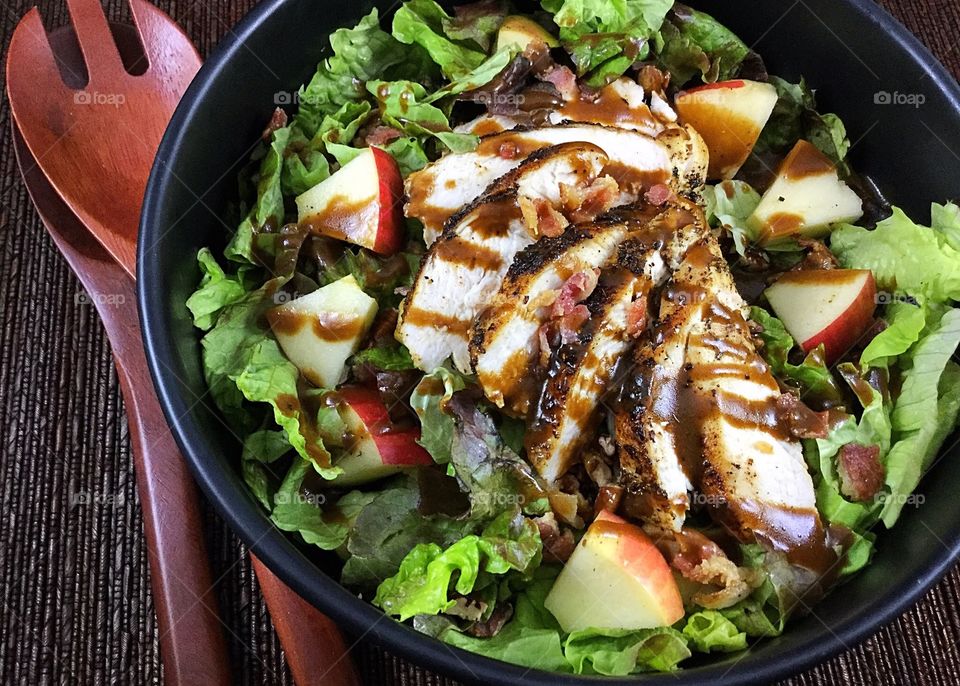 Salad topped with chicken, apples, and balsamic dressing