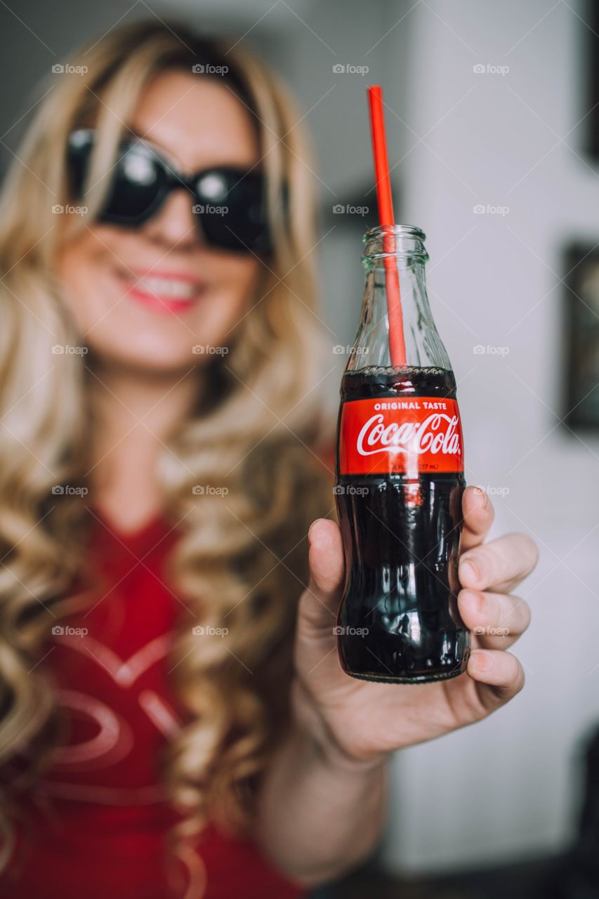 Blonde girl drinking Coca Cola 
