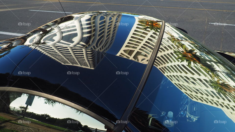 Building reflections on car. Abstract architectural reflections appear on the surface of a black car