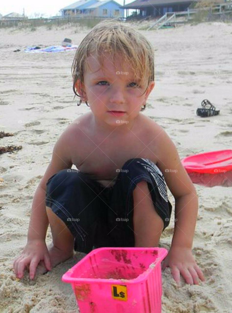 Smiling boy playing in sand at beach