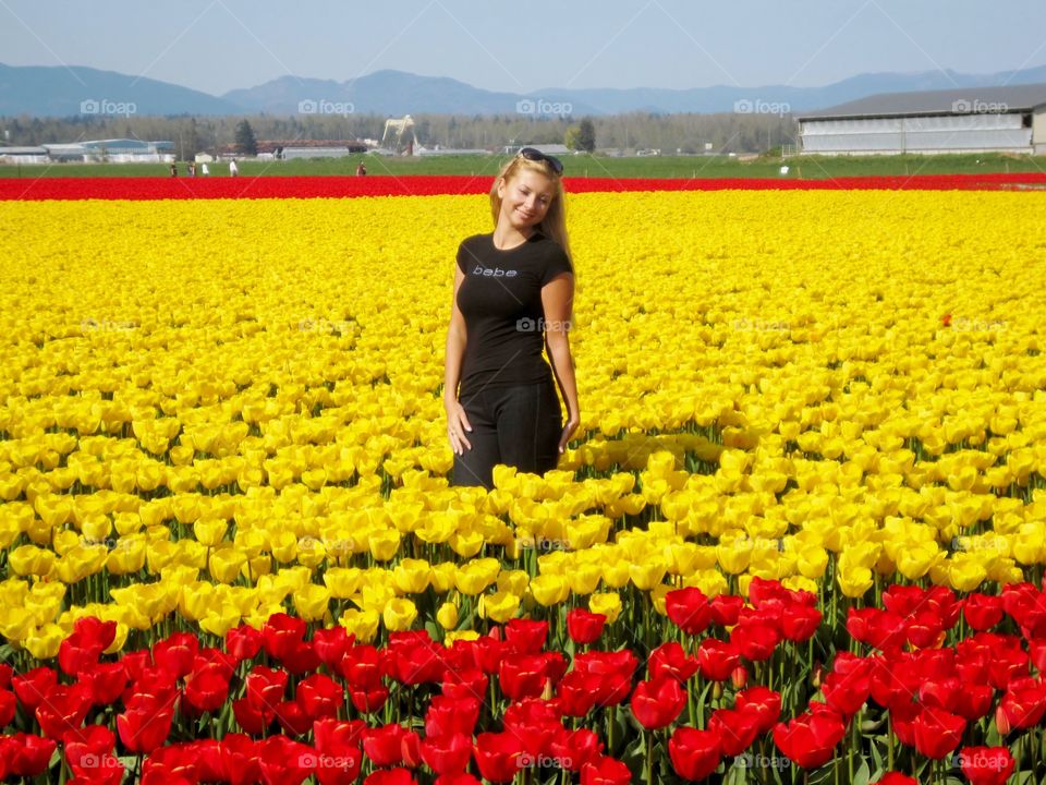 Young woman standing in tulip flower field