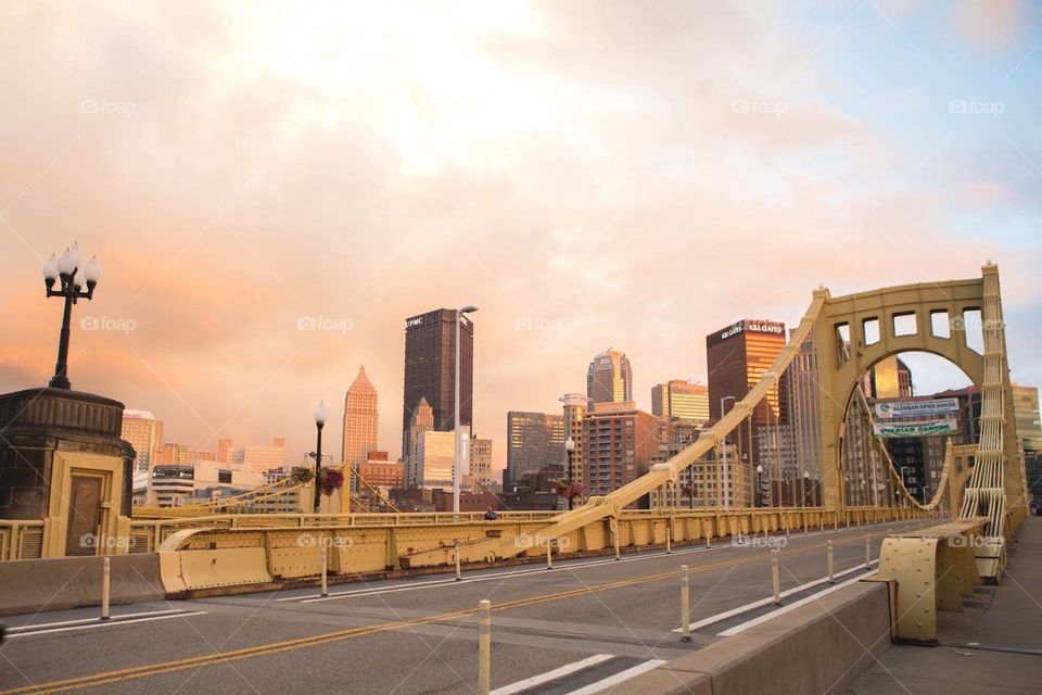 Clemente bridge and downtown skyline of Pittsburgh PA during a summer hazy sunset. 