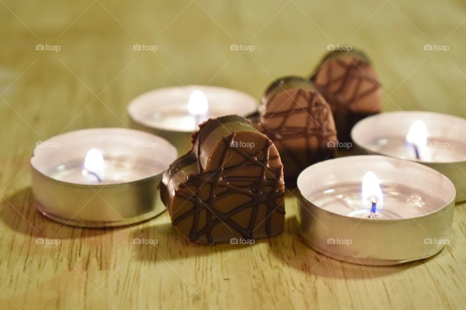 heart shaped chocolate candies with candles lit.  happy valentines day.