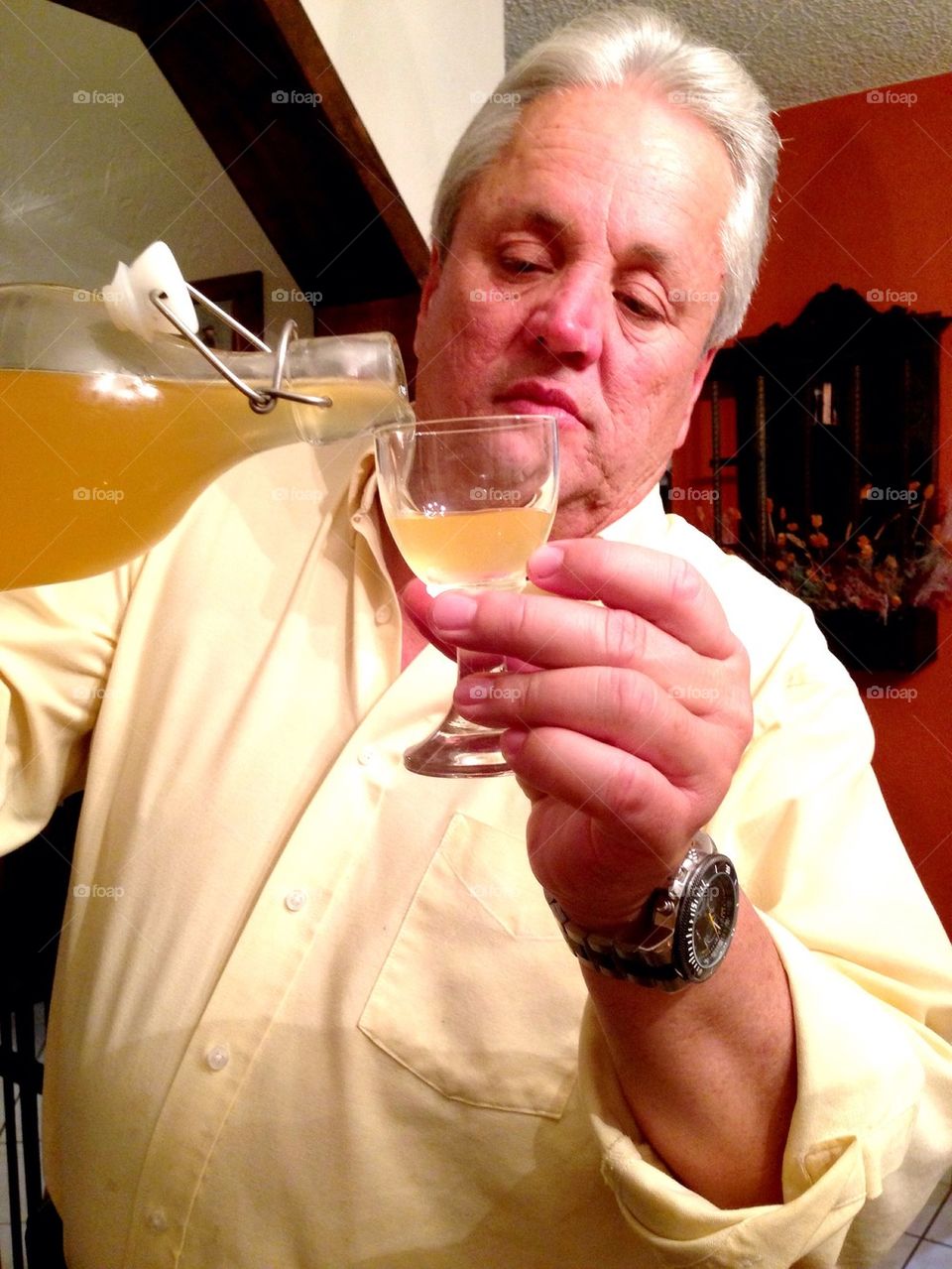 Man pouring liquor on glass in the house