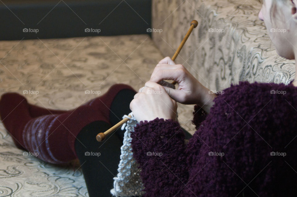 Girl knits on knitting sweater