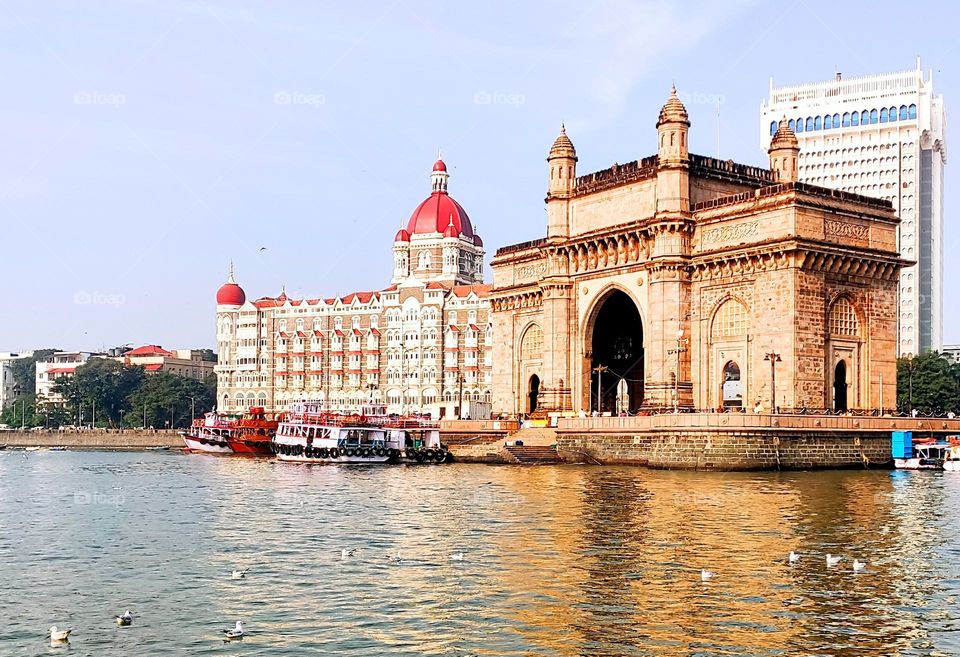 Gateway Of India and mighty Taj Hotel standing at bay of Arabian Sea with pride and joy for India. Proof of all the history India has seen in centuries and came out with flying colours. Boats taking tourist to Elphanta caves via sea.