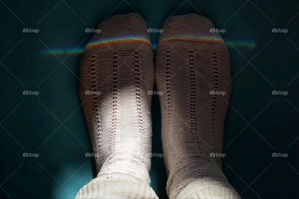 Refraction of light in rainbow colors on feet with white stockings